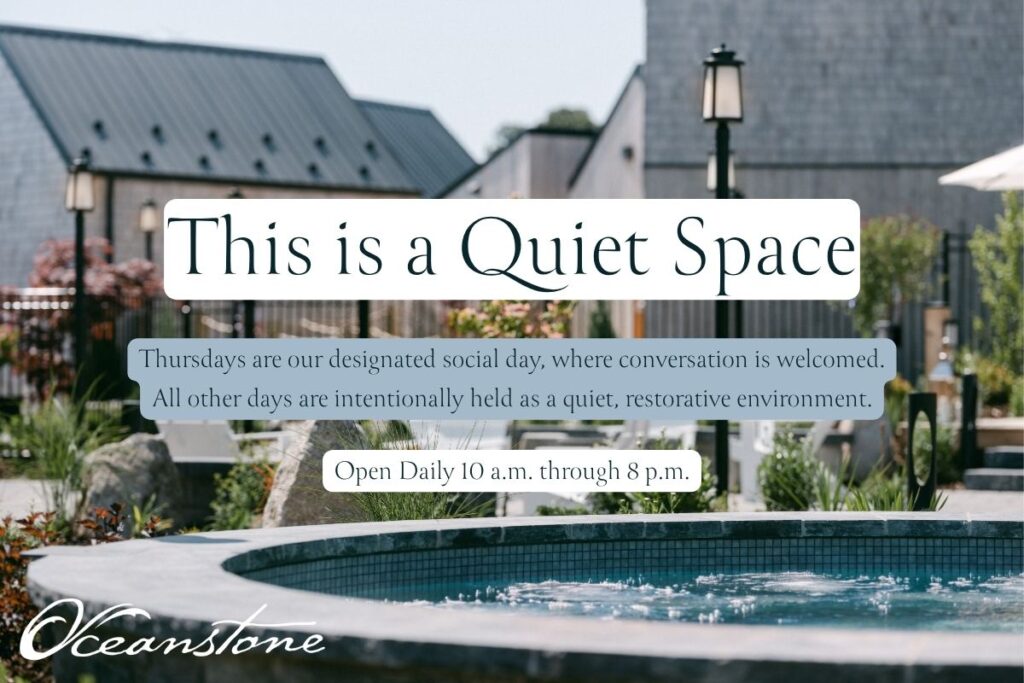 A tranquil circular outdoor pool with a gentle fountain is nestled within lush gardens, offering a peaceful, spa-like retreat at Oceanstone Resort and Spa. Surrounding buildings and abundant greenery create a serene ambiance, perfect for relaxation. A sign reads: “This is a Quiet Space. Thursdays are social; all other days are quiet. Open daily 10 a.m. to 8 p.m.” The elegant script “Oceanstone” appears at the bottom, emphasizing the resort’s soothing atmosphere.